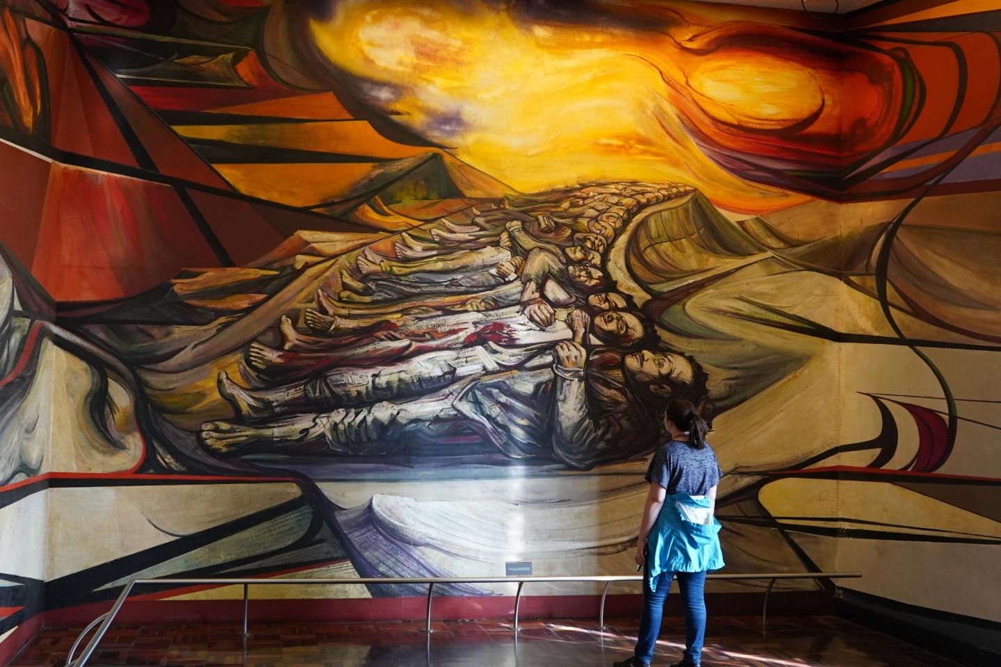 Student gazing at a huge 西班牙语 mural at an exhibit 