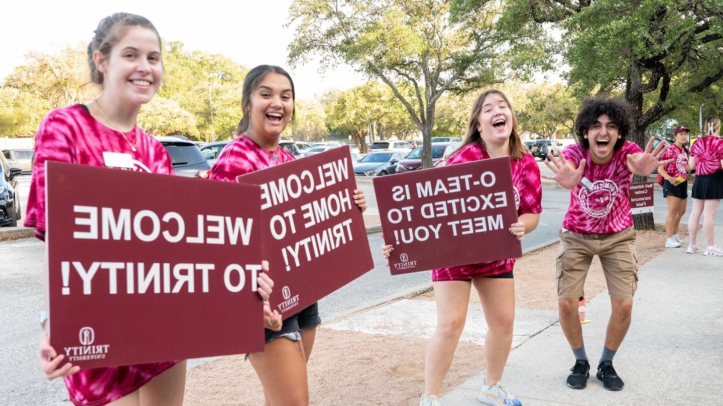 Students holding up sings welcoming new students to campus.